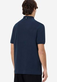Polo in cotone di colore navy, con colletto classico, maniche corte e orlo dritto, privo di motivi o dettagli visibili.