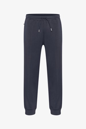 Tumedas sinised dressipüksid elastse vöökohaga, reguleeritava nööriga, küljetaskutega ja kitsenevate mansettidega. Valmistatud pehmest, kergest materjalist.