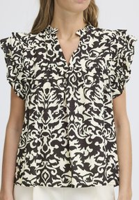 Blusa a motivo nero e crema con vestibilità rilassata, maniche arricciate e scollatura a V. Realizzata in tessuto leggero con elementi di design intricati.