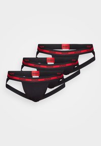 Schwarze Herrenunterhosen mit einem rot-schwarzen gestreiften elastischen Bund, auf dem das "Hugo"-Logo deutlich zu sehen ist. Dreierpack-Design.