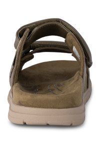 Bruna mockaskor med öppen baksida, justerbara remmar, vadderad innersula och gummisula. Texturerad yta på remmarna och innersulan.