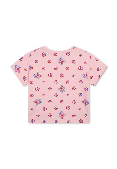 T-shirt rose clair avec un motif floral répétitif en rouge et bleu, agrémenté de lettres ludiques disposées ici et là.