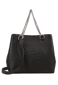 Sac fourre-tout en cuir noir à finition texturée, présentant un logo en relief, des anses en chaîne argentée et une bandoulière amovible.