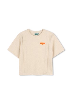 T-shirt cropped beige en coton, avec un col rond, des manches courtes et un logo orange sur la poitrine. Texture lisse.