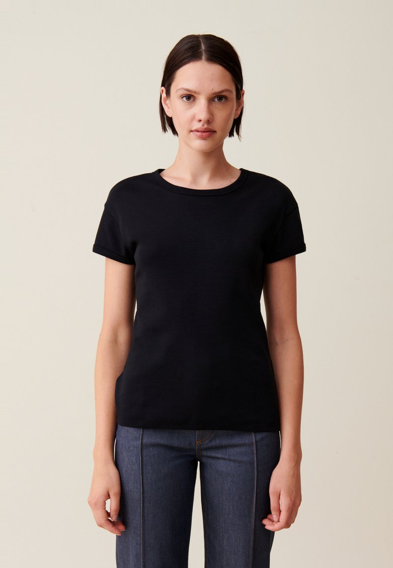 T-shirt noir à manches courtes avec un col rond, fabriqué à partir d'un tissu lisse. Présente une silhouette ajustée et des coutures minimales pour un look épuré.