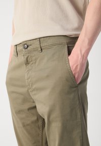Khaki cotton trousers featuring a straight cut, front pockets, button closure, and visible stitching details. Smooth texture and lightweight.