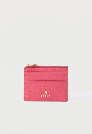 Porte-cartes compact en cuir rose avec fermeture éclair dorée sur le dessus et logo Furla en lettres dorées sur le devant.