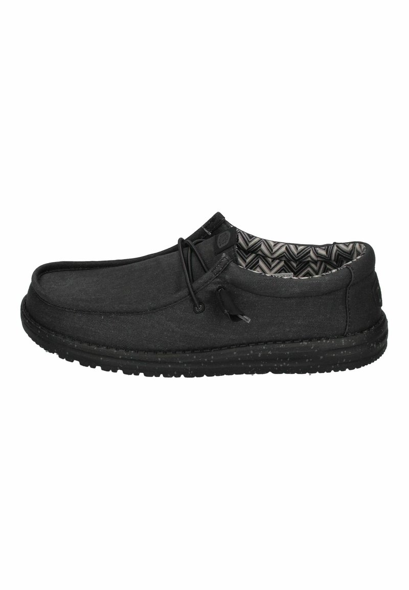 Schwarze Slipper aus weichem Stoff, mit einem gemusterten Innenfutter, elastischen Schnürsenkeln und einer Gummisohle mit strukturierten Details.