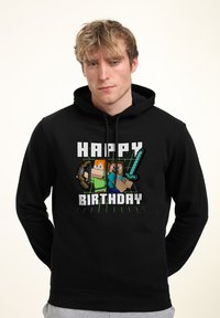 Sudadera negra con capucha que presenta un gráfico pixelado con personajes sosteniendo herramientas, el texto "FELIZ CUMPLEAÑOS" y una textura de tela suave.