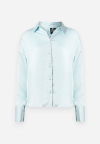 Lyseblå skjorte med lange ermer og knapper, som har en klassisk krage, mykt stoff og en lett cropped kant med oppbrettede ermer.