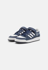 Mørkeblå lædersneakers med hvide detaljer, polstret tunge og Velcro-rem, med tre striber og tekstureret gummisål.