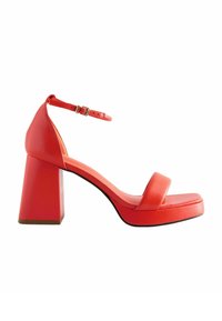 Röd fuskläder højhælet sandal med firkantet tå, ankelrem og kraftig klodsol. Glat tekstur med et minimalistisk design.