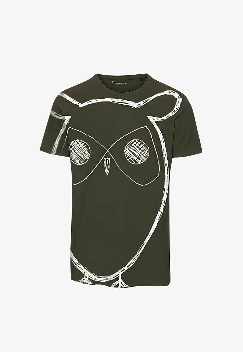 Σκούρο πράσινο κοντομάνικο t-shirt με μεγάλο λευκό σχέδιο σε στυλ σκίτσου που απεικονίζει το πρόσωπο και το σώμα μιας κουκουβάγιας, καλύπτοντας το μπροστινό μέρος και μέρος των μανικιών.