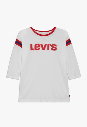Hvid langærmet skjorte med rød krave og røde og blå striber på ærmerne, med stor rød "LEVI'S" tekst på brystet.