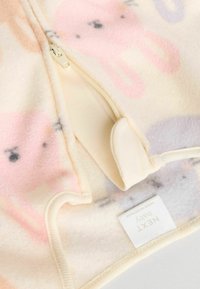 Fleece-Babybekleidung in Pastellrosa mit Tiermotiven. Mit Reißverschluss und weichem, strukturiertem Stoff. Etikett an der Unterseite befestigt.