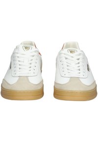 Bílé kožené tenisky s béžovými semišovými akcenty, gumovými podrážkami a bílými tkaničkami. Na boku a na patě mají zlaté logo.