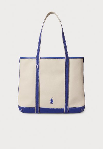 Krém vászonszínű testű, kék pántokkal és varrással díszített oldaltáska. Az elején apró, hímzett logó található.