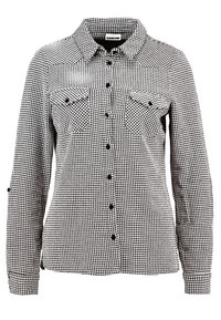 Chemise à manches longues à boutons avec motif pied-de-poule noir et blanc, deux poches à rabat à l'avant et col classique.