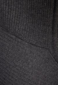 Mörkgrått stickat tyg med vertikal ribbning, som har en jämn textur och mjuk yta, perfekt för bekväm användning.