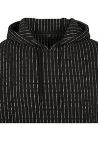 Sudadera con capucha negra con un patrón de texto vertical blanco que repite dos palabras en negrita y en mayúsculas.