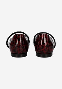 Chaussures en vernis avec un motif léopard rouge et noir, présentant un bout arrondi et une sangle élastique noire à l'arrière. Semelle plate.