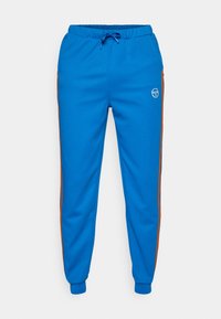 Zilo jogger bikses, kas izgatavotas no mīkstas auduma, ar sānu kabatām, elastīgu jostasvietu un brūnām sānu svītrām. Priekšpusē ir emblēma.
