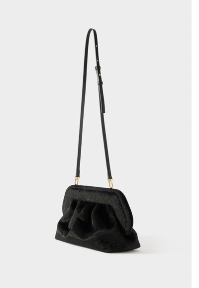 Borsa a mano in pelliccia nera con design imbottito, forma curvilinea e tracolla in pelle nera rimovibile. Presenta dettagli in metallo color oro.