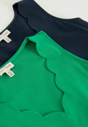 Dve tielka bez rukávov, jedno tmavomodré a druhé zelené, obe s vlnitými okrajmi výstrihu a štítkami "Láska & Ruže".