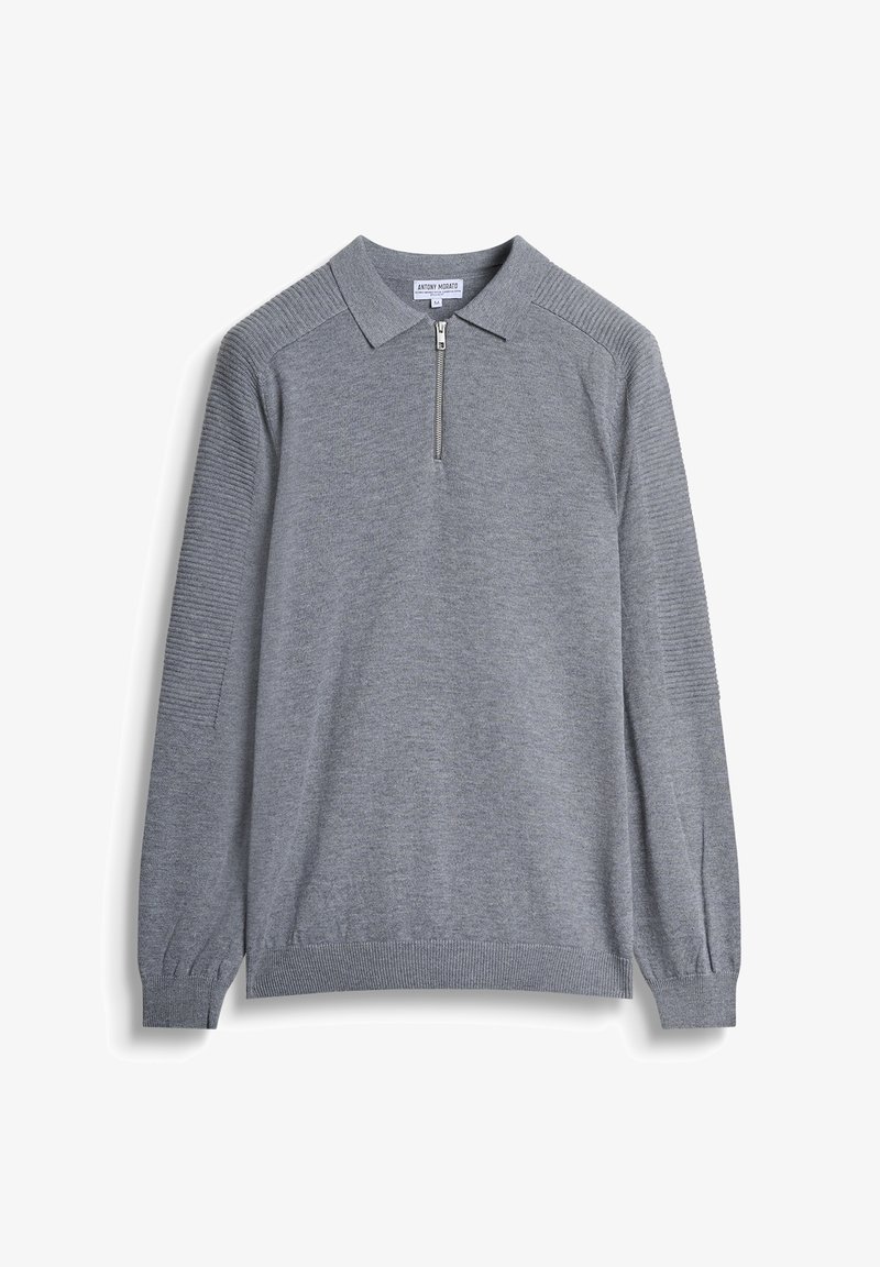 Siva pletena majica s dugim rukavima, s ovratnikom i polu zatvaračem. Ima teksturirane rukave te rebraste manžete i donji rub.