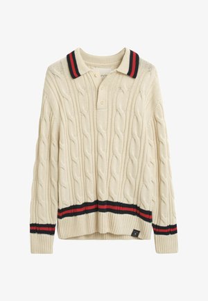 Pull polo en tricot à mailles torsadées crème avec un col et un ourlet rayés rouge et noir. Présente trois boutons au niveau du cou. Texture douce et coupe décontractée.