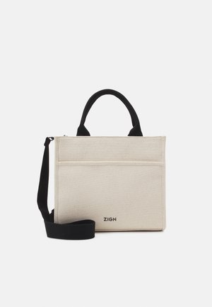 Sac fourre-tout rectangulaire beige avec poignées noires et bandoulière, poche avant et logo de la marque ZIGN en bas au centre.