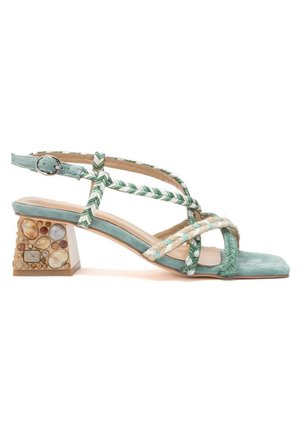 Sandale en daim bleu clair avec des brides tressées, une boucle réglable à la cheville, un bout carré et un talon bloc orné d'incrustations de pierres multicolores.