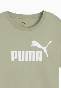 Oliivroheline T-särk, mis on valmistatud pehmest puuvillast, millel on suur valge "PUMA" logo ja hüppava puuma graafika. Ümmargune kaelus.