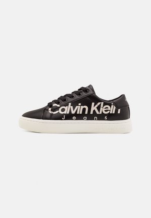 Czarne skórzane sneakersy z białymi podeszwami, z wyraźnym logo "Calvin Klein Jeans" w bieli, okrągłymi sznurowadłami oraz teksturowanym wierzchem.
