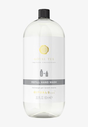 Klare Plastikflasche mit Nachfüll-Handwaschmittel, ausgestattet mit schwarzem Deckel, goldenen und grauen Akzenten sowie einem weißen Etikett mit Produkttext und Symbolen.