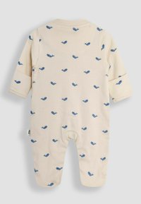 Romper para bebé color crema, hecho de tela suave, con un patrón de pequeñas ballenas azules y mangas largas, y un collar acanalado.