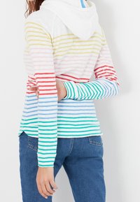 Haut à capuche rayé multicolore en tissu doux. Présente des rayures horizontales en jaune, rose, rouge, bleu et vert. Coupe décontractée, manches longues.