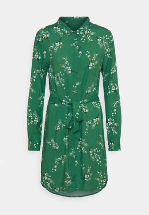 Vestido camisa verde de manga larga con cuello, cierre de botones frontal, cinturón en la cintura y patrón de ramas florales blancas.
