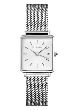 Montre carrée en argent avec un bracelet en maille argentée, cadran blanc texturé, index minimalistes et affichage de la date à 3 heures.
