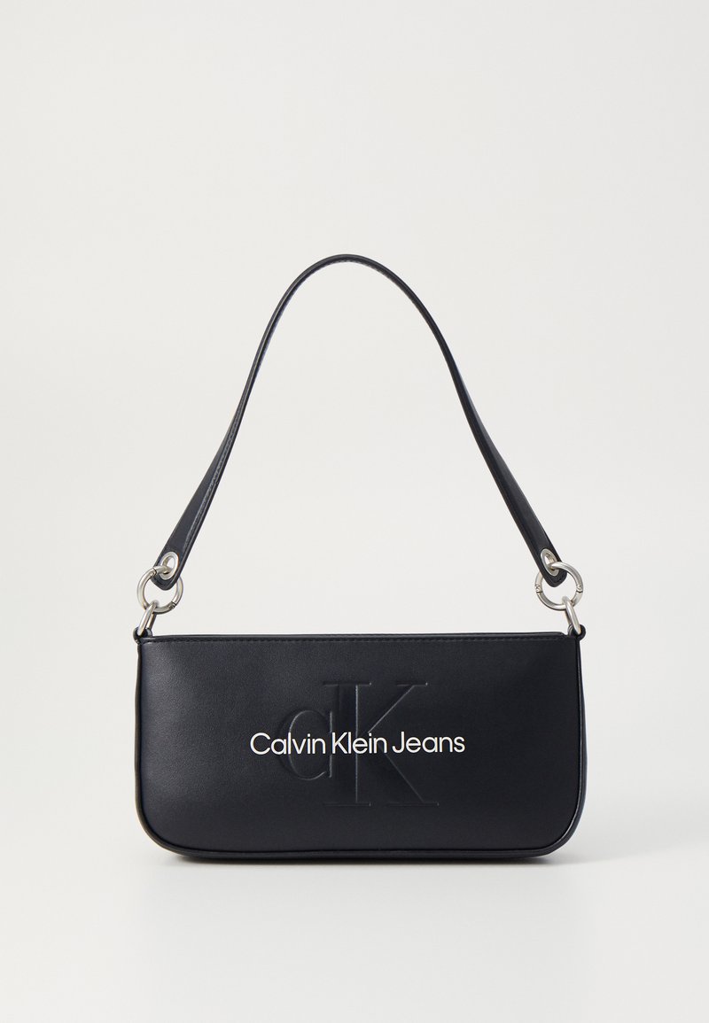 Fekete bőr kézitáska lapos, téglalap alakú, vállpánttal, a "CK" logóval domborítva, és "Calvin Klein Jeans" felirattal.