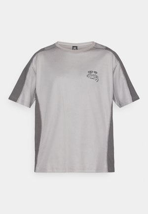 Light gray short-sleeve athletic shirt with darker gray panels on sleeves and sides, featuring a small abstract graphic and "Karma" text on chest.