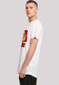 White cotton T-shirt featuring a large cartoon graphic in red and yellow on the front, with a relaxed fit and short sleeves.