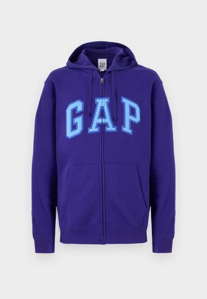 Purple zip-up hoodie with front pockets and light blue "GAP" lettering across the chest, featuring an adjustable drawstring hood.