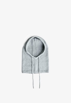 Cagoule grise tricotée avec une forme arrondie, des cordons de serrage et un ourlet côtelé en bas. Texture douce, design minimal sans motifs.