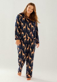 Navy pajamas made of soft fabric, featuring an all-over giraffe print in orange. Includes button-up top and matching pants with accents.