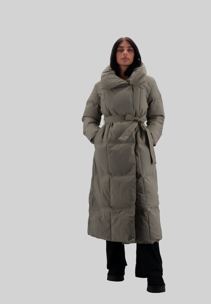 Abrigo puffer largo en verde oliva, con capucha grande, cintura ceñida con cinturón y silueta oversize con textura acolchada.