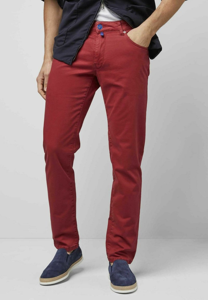 Rode katoenen broek met een blauwe accentknop, slim fit ontwerp en zakken. Gecombineerd met marineblauwe instappers met een gestructureerde afwerking.