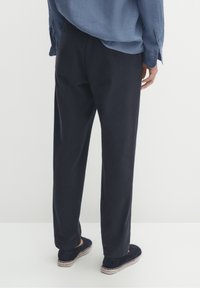 Marineblauwe chino's van lichtgewicht stof, met een losse pasvorm en rechte pijpen, gecombineerd met zwarte espadrilles met een gevlochten zool.