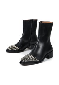 Czarne skórzane botki sięgające kostki z ostrym noskiem, zdobione srebrnymi ćwiekami z przodu, na niskim słupku i z zamkiem błyskawicznym z boku.