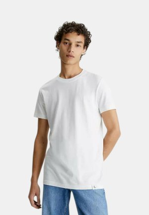 Witte t-shirt met korte mouwen van katoen, met een ronde hals en een ontspannen pasvorm, gecombineerd met blauwe jeans. Opvallend logo-detail.